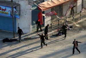 Palestinian security force officers from Hamas react near three dead bodies of other officers at the site of an Israeli airstrike in front of the Palestinian police headquarters in Gaza City, Saturday, Dec. 27, 2008. Israeli warplanes retaliating for rocket fire from Gaza pounded dozens of security compounds across the Hamas-ruled territory in unprecedented waves of air strikes that day, killing at least 155 and wounding more than 310 in the bloodiest day in Gaza in decades. (AP Photo/Adel Hana)