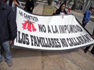 A family member of a student killed on July 18th, 1992 from La Cantuta University holds a poster that reads: "No to Impunity, the families won't be silenced!” (flickr via The Advocacy Project)